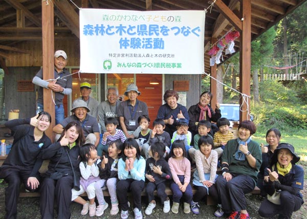 子供たちと先生と森ラボのおじさんたち(森のスギ小屋)