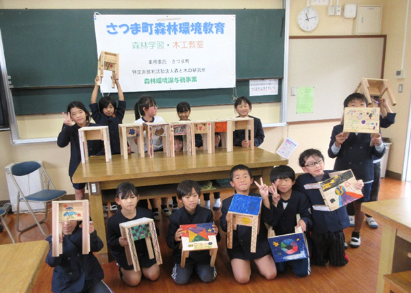 椅子づくりの木工教室で製作した椅子を手に鶴田小学校の3年生