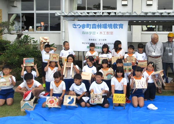 佐志小学校の3年生作ったイスを手に持って