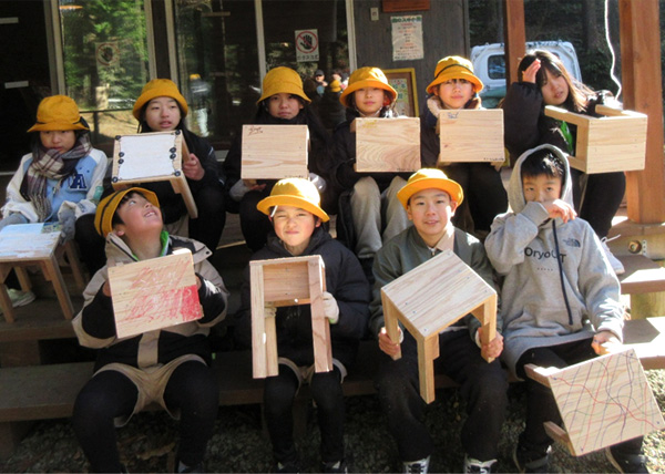 木工教室で作ったイスを前に頴娃郡緑の少年団